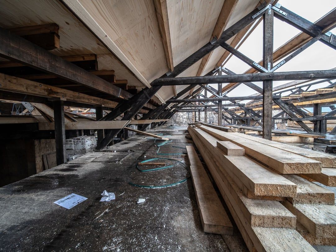 Offener Dachstuhl mit sichtbaren Holzsparren und freien Gefachen vor dem Innenausbau